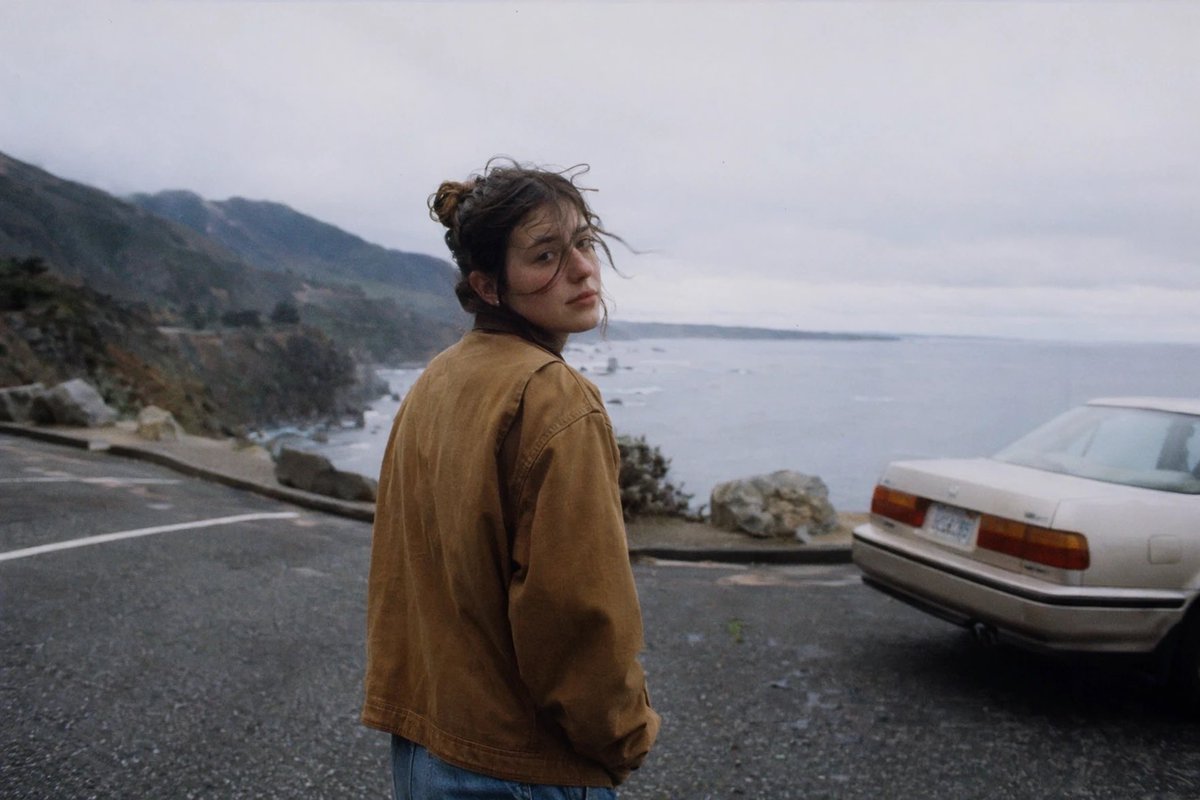 Woman, cinematic film style, mountain rain, melancholy